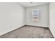This bedroom features soft carpeting, a window with a view, and neutral walls at 7977 Whisper Words Ave, Las Vegas, NV 89113