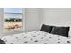 Bedroom with a window showcasing an outdoor view, features a comfortable bed with patterned bedding at 7977 Whisper Words Ave, Las Vegas, NV 89113