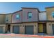 Row of modern townhouses, each with a one-car garage and a unique color scheme at 7977 Whisper Words Ave, Las Vegas, NV 89113