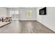 Open-concept living room with wood-look flooring, sliding glass doors, and a modern wall-mounted TV at 7977 Whisper Words Ave, Las Vegas, NV 89113