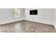 Minimalist bedroom with wood-look flooring, a window, and a modern wall-mounted TV at 7977 Whisper Words Ave, Las Vegas, NV 89113
