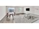 View from kitchen to the living area with wood floors, a TV, and a sliding glass door at 7977 Whisper Words Ave, Las Vegas, NV 89113