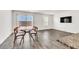 Open-concept living room with wood-look flooring, a dining table, and a modern wall-mounted TV at 7977 Whisper Words Ave, Las Vegas, NV 89113