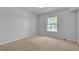 Neutral bedroom featuring a large window, carpet floors, and white painted walls and doors at 8000 Badura Ave # 2174, Las Vegas, NV 89113