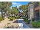 Beautifully landscaped apartment complex exterior with mature trees and well-maintained walkways on a sunny day at 8000 Badura Ave # 2174, Las Vegas, NV 89113