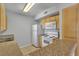 Galley kitchen features standard appliances, wood cabinets, and a breakfast bar at 8000 Badura Ave # 2174, Las Vegas, NV 89113