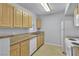 Galley kitchen with wood cabinets, standard appliances, and ample counter space at 8000 Badura Ave # 2174, Las Vegas, NV 89113