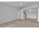 Open-concept living room featuring neutral carpeting and access to a hallway and kitchen at 8000 Badura Ave # 2174, Las Vegas, NV 89113