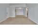 Open-concept living room featuring neutral carpeting and a view of the front door and kitchen at 8000 Badura Ave # 2174, Las Vegas, NV 89113