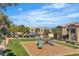 Community playground with modern play equipment, surrounded by lush greenery and residential buildings at 8000 Badura Ave # 2174, Las Vegas, NV 89113