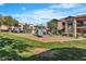 Community playground area with slides, climbing structures, and a grassy area for to enjoy outdoors at 8000 Badura Ave # 2174, Las Vegas, NV 89113