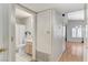 Hallway view of a bathroom, showcasing white fixtures, a toilet, and a tiled floor at 8450 Alta Dr # 204, Las Vegas, NV 89145