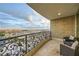 Relaxing balcony with wrought iron railing, stone wall and two chairs overlooking city views at 9103 Alta Drive Dr # 407, Las Vegas, NV 89145