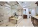 Elegant bathroom featuring a walk-in shower, soaking tub, and dual vanities with travertine tile at 9103 Alta Drive Dr # 407, Las Vegas, NV 89145