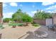 Spacious backyard with mature trees, gravel, a stone firepit and well-maintained landscaping at 9375 Gold Lake Ave, Las Vegas, NV 89149