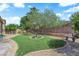 Well-maintained backyard featuring a grassy area, mature landscaping, and decorative elements at 9375 Gold Lake Ave, Las Vegas, NV 89149