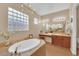 Elegant bathroom with a soaking tub, vanity, and a stylish chandelier at 9375 Gold Lake Ave, Las Vegas, NV 89149