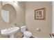 Cozy powder room featuring pedestal sink and decorative framed art for a touch of elegance at 9375 Gold Lake Ave, Las Vegas, NV 89149