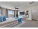 Bright main bedroom with windows, ceiling fan, ensuite bath, and modern TV at 10024 Rams Leap Ave, Las Vegas, NV 89166