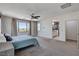 Bright bedroom featuring carpet, a ceiling fan, and access to the ensuite bath at 10024 Rams Leap Ave, Las Vegas, NV 89166