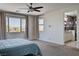 Bright bedroom with a modern ceiling fan, large windows, and an ensuite bathroom featuring a glass enclosed shower at 10024 Rams Leap Ave, Las Vegas, NV 89166