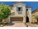 Charming two-story home featuring a brick driveway, arched entryway, and blue shutters at 10024 Rams Leap Ave, Las Vegas, NV 89166