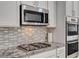 Modern kitchen features stainless steel appliances, stylish backsplash, and granite countertops at 10024 Rams Leap Ave, Las Vegas, NV 89166