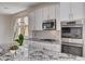 Modern kitchen featuring white cabinets, stainless steel appliances, granite countertops, and stylish backsplash at 10024 Rams Leap Ave, Las Vegas, NV 89166