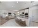 Open-concept kitchen with granite island, barstool seating, and stainless steel appliances overlooking living area at 10024 Rams Leap Ave, Las Vegas, NV 89166
