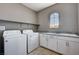 Functional laundry room with a washer, dryer, granite countertop, and sink at 10024 Rams Leap Ave, Las Vegas, NV 89166
