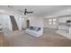 Open concept living space with a staircase, cozy seating, and a view into the modern kitchen at 10024 Rams Leap Ave, Las Vegas, NV 89166