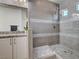 Modern shower showcasing grey tiling, a glass enclosure, and marble mosaic accents, next to a granite vanity at 10024 Rams Leap Ave, Las Vegas, NV 89166