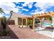 Charming backyard with covered patio, pergola, a swimming pool and desert landscape features at 10058 Saint Augustine St, Las Vegas, NV 89183