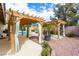 Backyard retreat featuring a covered patio, pergola, and swimming pool with desert landscaping at 10058 Saint Augustine St, Las Vegas, NV 89183