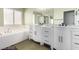 Bathroom featuring dual vanities, sleek fixtures, and a soaking tub beneath a window for a bright, airy ambiance at 10058 Saint Augustine St, Las Vegas, NV 89183