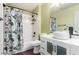 Bright bathroom features a shower-tub combination with a floral curtain and a modern sink vanity at 10058 Saint Augustine St, Las Vegas, NV 89183
