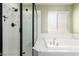 Bathroom featuring a glass enclosed shower, soaking tub with a window, and modern fixtures at 10058 Saint Augustine St, Las Vegas, NV 89183