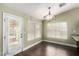 Bright dining area featuring a contemporary chandelier, large windows, and a door leading to outdoor space at 10058 Saint Augustine St, Las Vegas, NV 89183