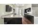 Modern kitchen featuring dark cabinets, stainless steel appliances, granite countertops, and dark wood floors at 10058 Saint Augustine St, Las Vegas, NV 89183