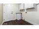 Functional laundry room with overhead cabinets, utility sink and a white painted entry door at 10058 Saint Augustine St, Las Vegas, NV 89183
