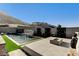 Modern backyard featuring a sleek pool, fire pit, and contemporary landscaping against a hillside backdrop at 10228 Shell Star Ave, Las Vegas, NV 89135