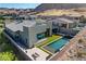 Aerial view of a modern backyard with a pool, spa, fire pit, and lush turf at 10228 Shell Star Ave, Las Vegas, NV 89135