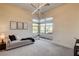 Bright bedroom featuring a modern chandelier, large windows, and a comfortable chaise lounge at 10228 Shell Star Ave, Las Vegas, NV 89135