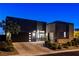 Contemporary home with a dark exterior, well-manicured landscaping, and a paved driveway at 10228 Shell Star Ave, Las Vegas, NV 89135