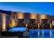 Relaxing hot tub adjacent to a pool, featuring privacy screens and ambient lighting for evening enjoyment at 10228 Shell Star Ave, Las Vegas, NV 89135