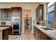 Modern kitchen with stainless steel appliances, wooden cabinetry, and a pantry at 10228 Shell Star Ave, Las Vegas, NV 89135