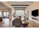 Open-concept living room with wood-look tile floors, fireplace, and views of the outdoor patio at 10228 Shell Star Ave, Las Vegas, NV 89135