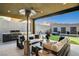 Outdoor patio with a grill, seating, and a view of the pool and water feature, perfect for entertaining at 10228 Shell Star Ave, Las Vegas, NV 89135