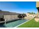 Relaxing backyard featuring a pool, a cascading waterfall, and an upper deck seating area with a cozy fire pit at 10228 Shell Star Ave, Las Vegas, NV 89135