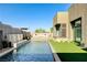 Modern pool with waterfall feature and seating area, surrounded by lush landscaping at 10228 Shell Star Ave, Las Vegas, NV 89135
